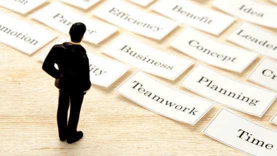 Professional toy figure on table looking at business keywords